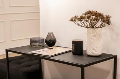 a black table with a white vase and a vase at Blanq Comedias in Valencia