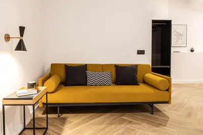 a yellow couch in a living room with a table at Blanq Comedias in Valencia