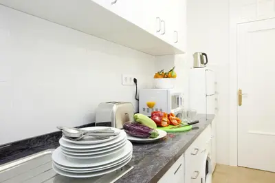 a kitchen with plates and fruits and vegetables on a counter at SingularStays Seu Catedral in Valencia
