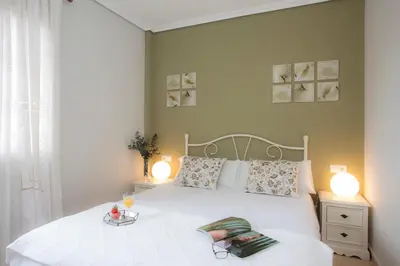 a bedroom with a white bed with two lamps at SingularStays Puzol Beach VII in Puzol
