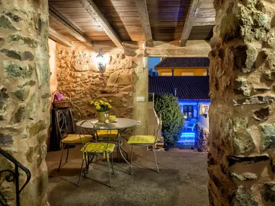 a table and chairs in a room with a stone wall at Valterra y Tosal in Torres-Torres