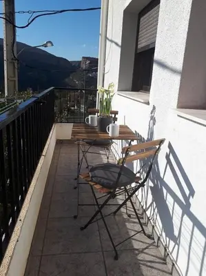 a patio with a table and chairs on a balcony at APARTAMENTO LOS NARCISOS in Chulilla