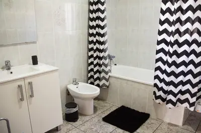 a bathroom with a toilet and a shower curtain at APARTAMENTO LOS NARCISOS in Chulilla