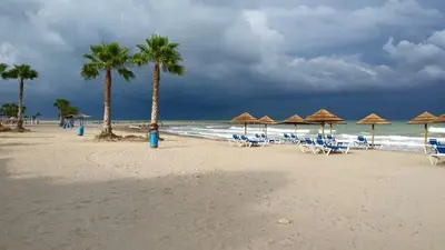 a beach with chairs and umbrellas and the ocean at El apartamento de Marina en Chilches playa in Xilxes
