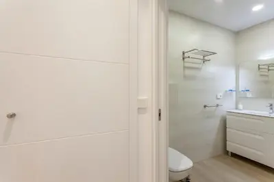 a white bathroom with a toilet and a sink at ApartUP Patacona Select in Valencia