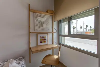 a room with a window and wooden shelves and a chair at ApartUP Patacona Select in Valencia