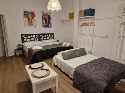 a hotel room with two beds and a table at Style Apartments Cabanyal Marina Beach in Valencia