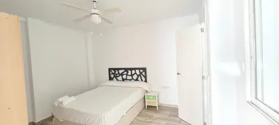 a white bedroom with a bed and a ceiling fan at Style Apartments Cabanyal Marina Beach in Valencia