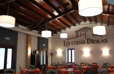 a dining room with tables and chairs and lights at Hotel-Restaurante Casa Blava Alzira in Alzira