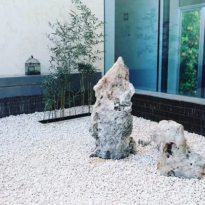 a rock sitting on the ground in front of a building at Hotel-Restaurante Casa Blava Alzira in Alzira