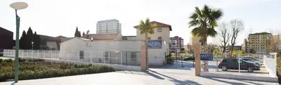 a city street with a fence and a parking lot at Hotel-Restaurante Casa Blava Alzira in Alzira