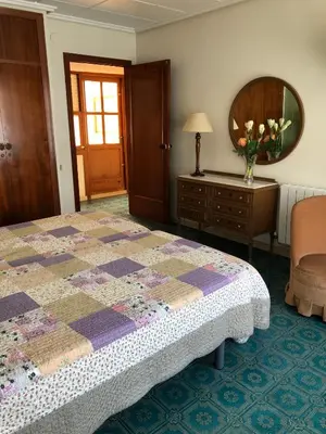 a bedroom with a bed and a table with a vase of flowers at Casa Rural 