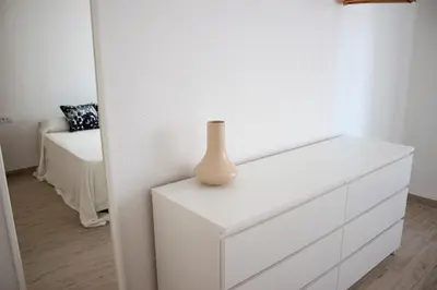 a white dresser with a vase on top of it at Campanar flat 2 in Valencia