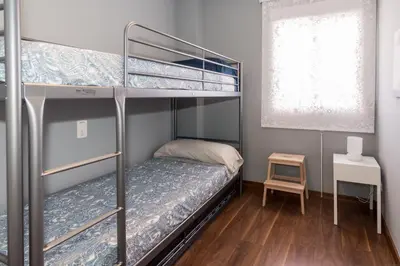 a bedroom with two bunk beds and a table at Duplex Penthouse with terrace. Beach-Pool in Canet de Berenguer