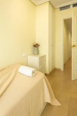 a bedroom with a bed with a white blanket on it at City Center Apartment in Valencia