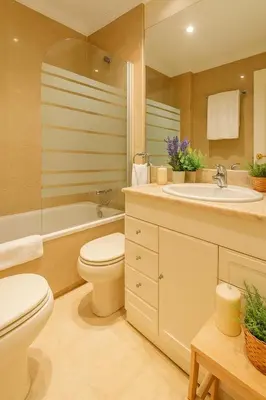 a bathroom with a toilet and a sink and a tub at City Center Apartment in Valencia