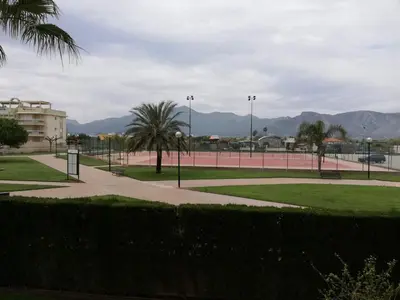 a park with palm trees and a tennis court at Parquemar VIII Solo Familias Serviplaya in Playa de Xeraco