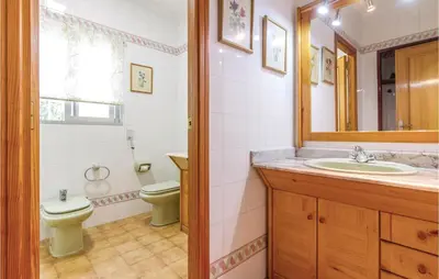 a bathroom with a sink and a toilet and a mirror at 2 Bedroom Cozy Home In Faro De Cullera in Faro de Cullera