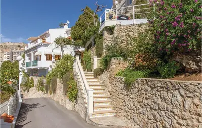 a stone wall with stairs leading up to a house at 2 Bedroom Cozy Home In Faro De Cullera in Faro de Cullera