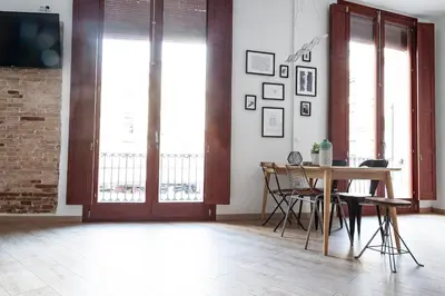 a dining room with a table and chairs and windows at Plaza Redonda Center in Valencia