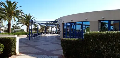 a building with tables and chairs and palm trees at PATACONA MARE NOSTRUM APARTMENT II in Valencia