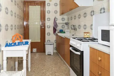 a kitchen with a stove and a microwave at AGUAMARINA C, 11-51 in Cullera