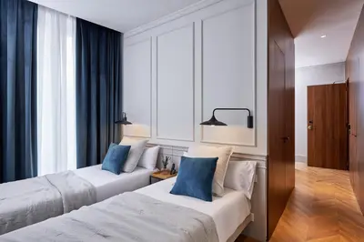 two beds in a hotel room with blue pillows at Room Mate Collection Helen Berger in Valencia