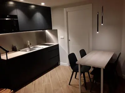 a kitchen with a table and chairs and a sink at SLEEP TURIA LLIRIA in Lliria