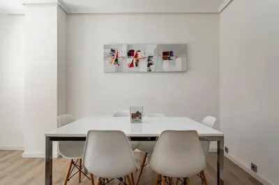 a white dining room with a table and white chairs at Garden Turia Downtown in Valencia