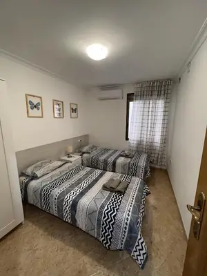 two beds sitting in a room with a window at Moderno y acogedor apartamento para 6 personas in Valencia