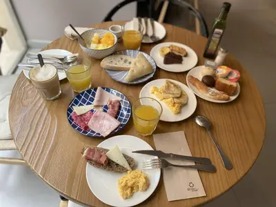 a wooden table with plates of breakfast food on it at YOU & CO. Quart Boutique in Valencia