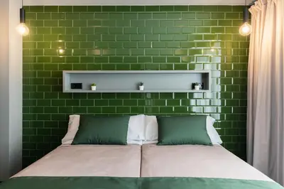 a bedroom with a green brick wall and a bed at Nest Style Valencia in Valencia