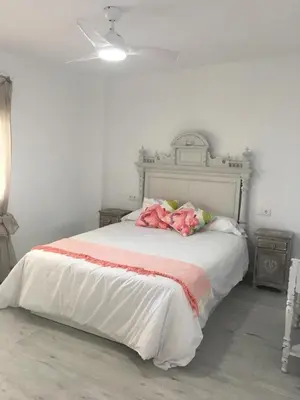 a bedroom with a white bed with a red and white blanket at Casa Ferrada in Burriana
