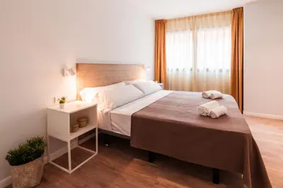 a bedroom with a bed and a table with towels on it at Lindala in Valencia