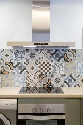 a kitchen with a stove and a tile wall at FLORIT FLATS - CATHEDRAL LUXURY TERRACE FLAT 2BR 2BA AC Wifi in Valencia
