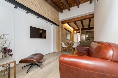 a living room with a leather couch and a table at FLORIT FLATS - CATHEDRAL LUXURY TERRACE FLAT 2BR 2BA AC Wifi in Valencia
