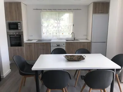 a kitchen with a white table and chairs at Sun & Beach Pobla in Puebla de Farnals