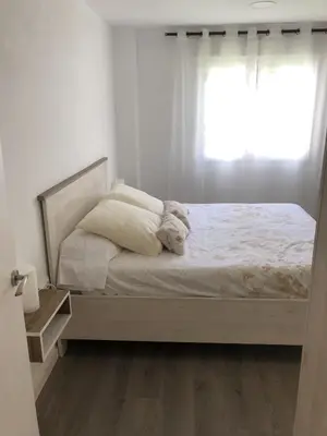 a white bedroom with a bed with a window at Sun & Beach Pobla in Puebla de Farnals