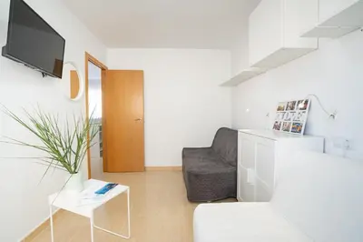 a white living room with a couch and a tv at Ideally Located Holiday Apartment in Moncófar