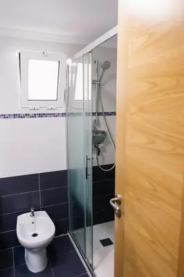a bathroom with a toilet and a glass shower at Vacaciones en Valencia in Burjasot