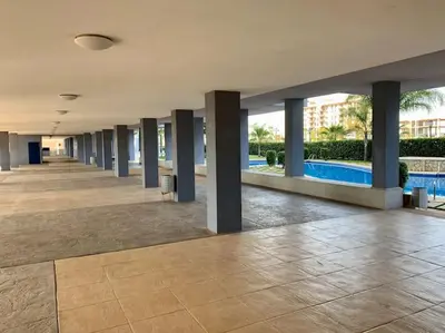 a hallway in a building with a pool and columns at The Apartment Olivia in Moncófar