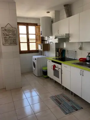 a kitchen with white cabinets and a tile floor at Apartamento Puerto de Sagunto Playa in Puerto de Sagunto