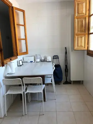 a kitchen with a table and chairs in a room at Apartamento Puerto de Sagunto Playa in Puerto de Sagunto