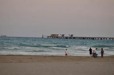 a group of people standing on a beach near the ocean at Apartamento Puerto de Sagunto Playa in Puerto de Sagunto
