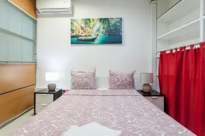 a bedroom with a large bed with red curtains at Catedral Reina Apartaments in Valencia