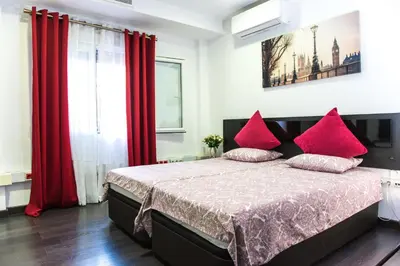 a bedroom with red curtains and a bed with red pillows at Catedral Reina Apartaments in Valencia