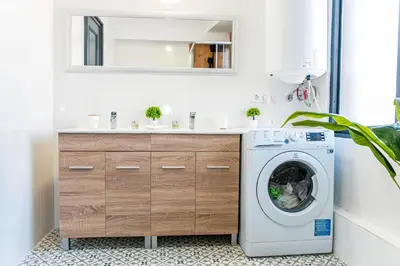 a bathroom with a washing machine and a sink at Catedral Reina Apartaments in Valencia