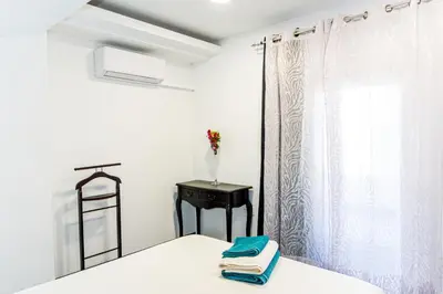 a bedroom with a bed and a table and a window at Catedral Reina Apartaments in Valencia