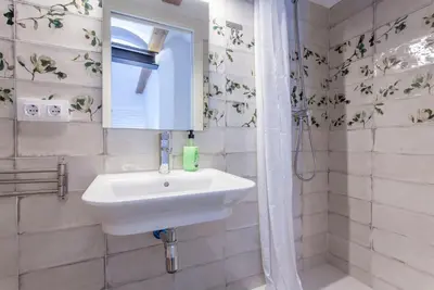 a bathroom with a sink and a shower and a mirror at ApartUP Central Market II in Valencia