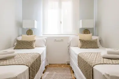 two beds in a room with white walls and a window at MD Pasaje Ruzafa in Valencia